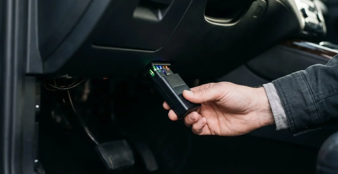 Outil de diagnostic OBD2 connecté au port d'un véhicule moderne, symbolisant l'auto-diagnostic automobile accessible et les économies de réparation