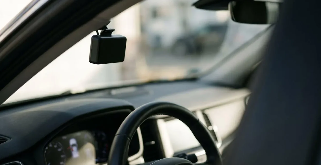 Conducteur au volant face à un dilemme entre économie et surveillance avec boîtier télématique