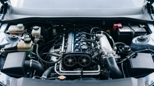 Vue détaillée d'un compartiment moteur automobile moderne avec composants clés visibles, symbolisant la maintenance préventive et l'entretien mécanique